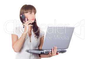 Businesswoman with laptop speaks on the cell phone