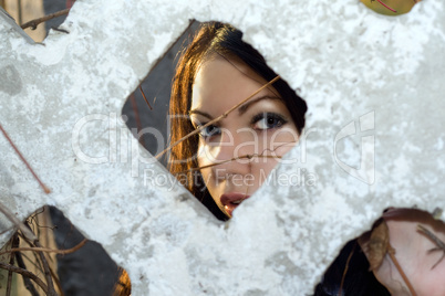 The young woman looks through a fence