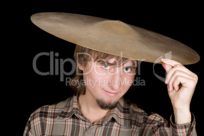 The young man with a plate from a drum on a head