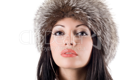 Portrait of the young woman in a fur cap