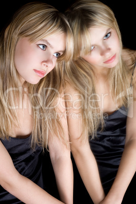 Portrait of the young blonde near a mirror