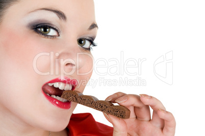 Portrait of the beautiful young woman eating chocolate