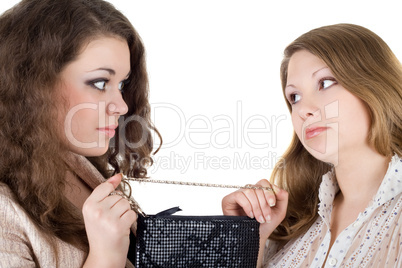 Two beautiful girls and one handbag. Isolated