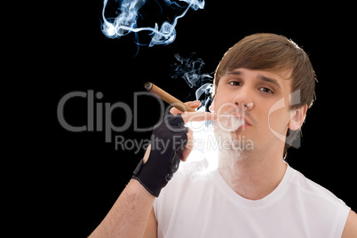 Young man smoking a cigar. Isolated on black