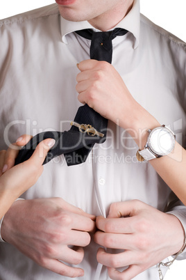 Young man, a tie and female hands. Isolated