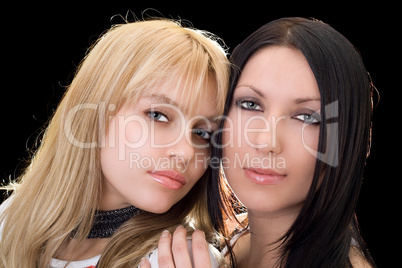 Portrait of the young brunette and blonde. Isolated on black