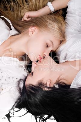 Portrait of the two lying kissing girlfriends