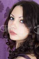 Portrait of the pretty girl on a violet background
