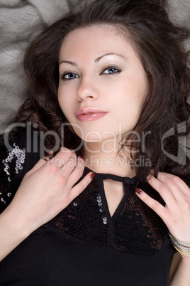 Sexy girl lying on grey fur coat