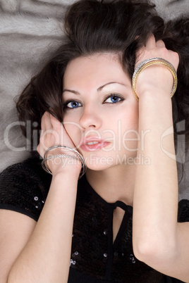 Portrait of the attractive lady lying on grey fur