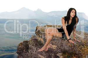 Pretty girl sits on a rock