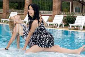 Two playful girlfriends in pool