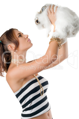 Pretty young woman playing with rabbit