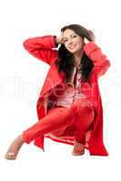 Playful young woman in red suit. Isolated