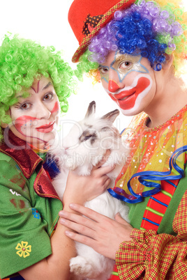 Two smiling clown with a white rabbit