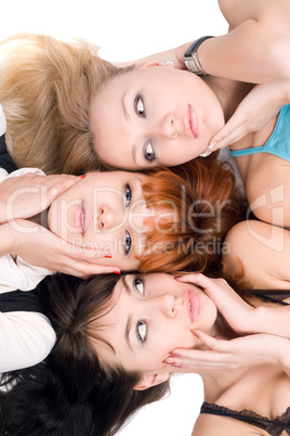 Three young women touching their cheeks