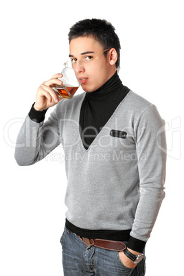 Young man drinking whiskey from a glass. Isolated