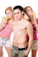 Young man and two beautiful women with bananas