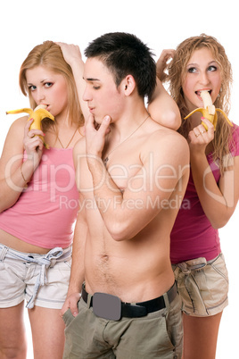 Young man and two playful women with bananas