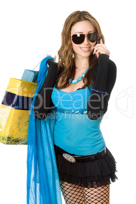 Pretty young woman talking on the phone after shopping