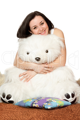 Smiling girl sitting in an embrace with a teddy bear