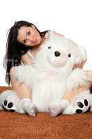 Lovely girl sitting in an embrace with a teddy bear