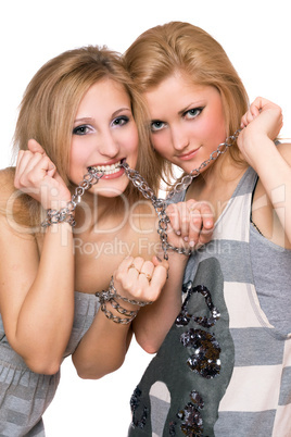 Two playful young women bound a chain