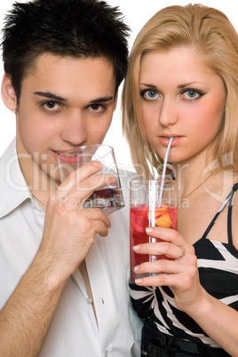 Beautiful young couple with cocktails. Isolated