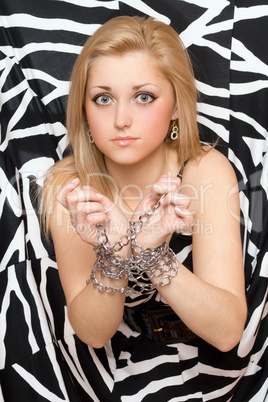Pretty woman stretches out her hands in chains