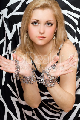 Sensual blonde stretches out her hands in chains