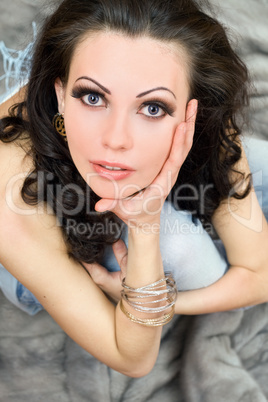 Beautiful brunette sitting on grey fur