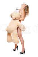 naked young woman posing with large teddy bear