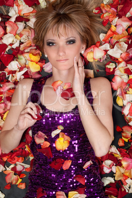 young blonde lying in rose petals