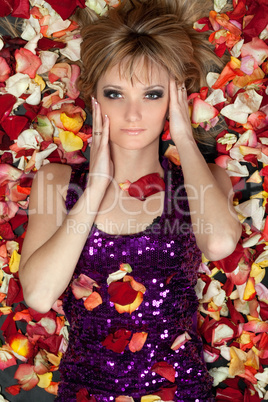 young blonde lying in rose petals