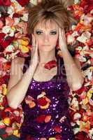 young blonde lying in rose petals