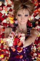 charming young blonde lying in rose petals