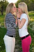 Portrait of two playful kissing blonde