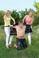 Two playful blonde and young man outdoors