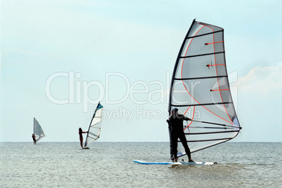 Silhouettes of a three windsurfers