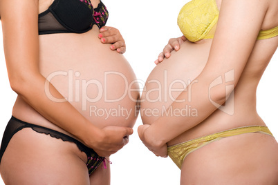 Two bellies of pregnant young women. Isolated