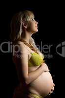 Happy pregnant young woman in yellow lingerie. Isolated