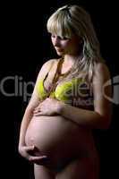 Young pregnant woman in yellow lingerie. Isolated