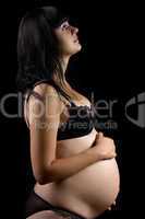 Pregnant young brunette in lingerie. Isolated
