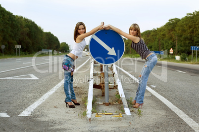 Two girls stand on a road