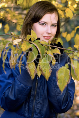 smiling girl amongst the autumn leaves