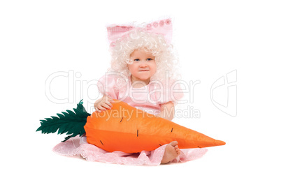Funny baby girl plays with a carrot