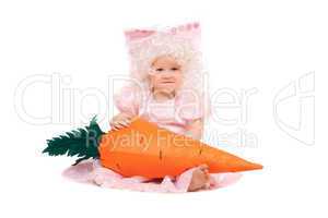 Funny baby girl plays with a carrot