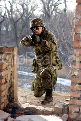 Soldier sitting near wall with a gun