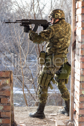Soldier standing near wall with a gun