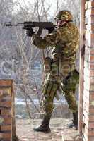 Soldier standing near wall with a gun